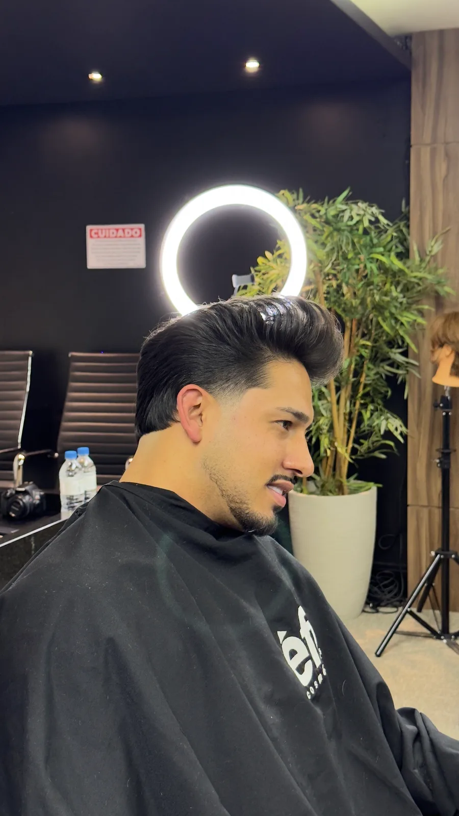 Cliente com corte finalizado na cadeira da barbearia