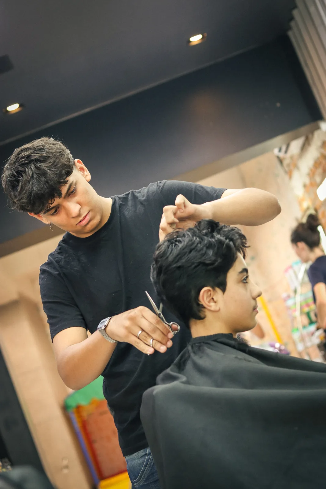 João, barbeiro da OS BEAUTY, atendendo um cliente