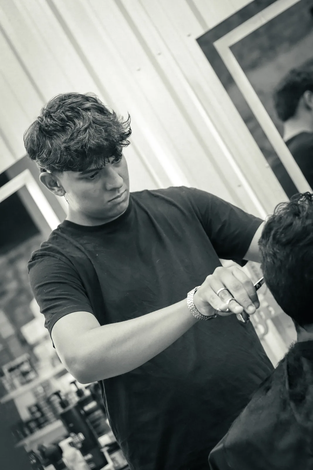 Barbeiro trabalhando com tesoura no cabelo de um cliente